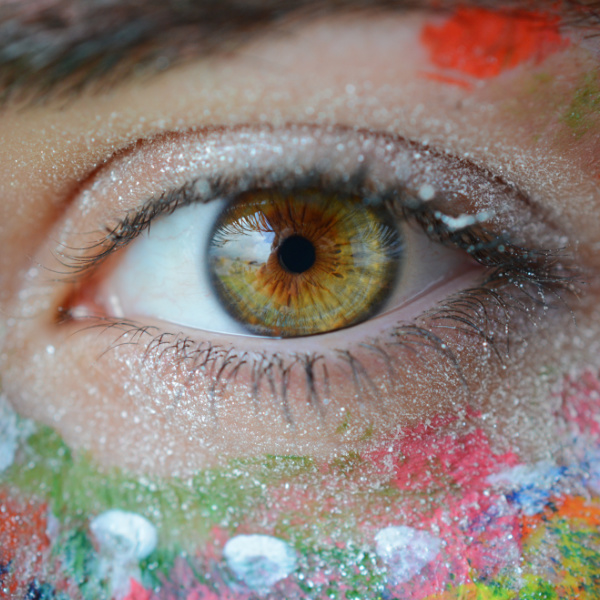 ojo verde y marrón rodeado de colores en la piel